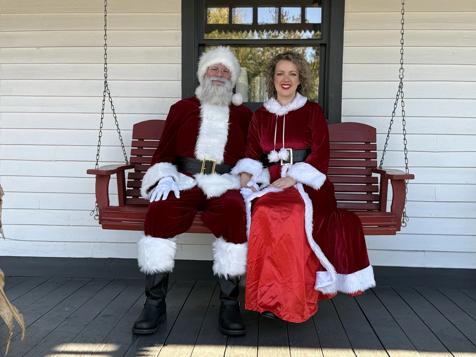 Santa and Mrs. Claus together on the red porch swing